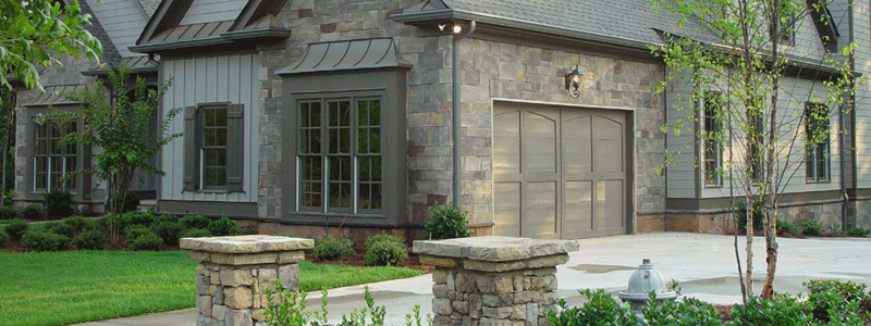 a house with white siding and Centurion manufactured stone veneers on garage walls