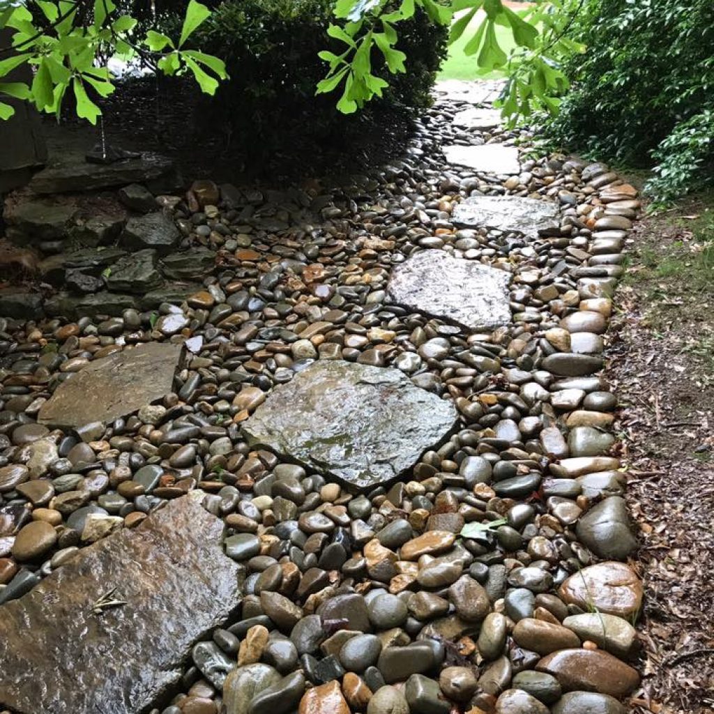 a pathway made with river rocks and fieldstone used as stepping stones